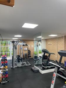 a gym with several treadmills and a mirror at LINDO LOFT, PISCINA, ESTACIONAMENTO, ACADEMIA, AR CONDICIONADO, Wi-Fi in Sao Paulo