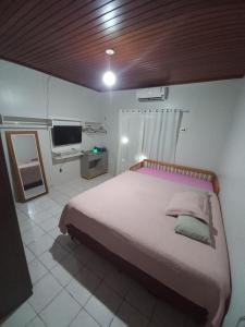 een slaapkamer met een groot bed en een televisie bij CASA COM PISCINA EM ÁREA NOBRE in Boa Vista