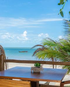 een tafel op het strand met uitzicht op de oceaan bij Pousada Preamar in Prea