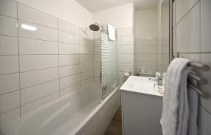 y baño blanco con lavabo y ducha. en L'Aiglon Bylitis, en Porto Vecchio
