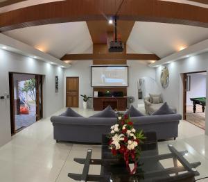 ein Wohnzimmer mit 2 Sofas und einem TV in der Unterkunft Pool Villas by Honey-5 miles from central Pattaya Beach in Nong Prue