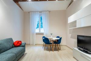a living room with a couch and a table and chairs at Casa L - Mimbelli Park Modern Quiet Apartment in Livorno