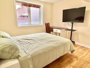1 dormitorio con 1 cama y TV de pantalla plana en Cozy Detached Home in Richmond Hill en Richmond Hill