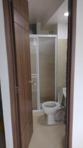 baño con aseo y puerta de cristal en Cómodo Apartamento, Hacienda Peñaliza - Ricaurte, en Ricaurte