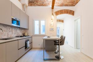 a kitchen with white cabinets and a table with chairs at Casa L - Mimbelli Park Modern Quiet Apartment in Livorno