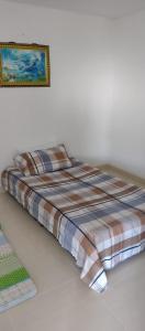 1 cama en una habitación con una foto en la pared en Cómodo Apartamento, Hacienda Peñaliza - Ricaurte, en Ricaurte