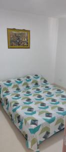 1 cama en una habitación con una foto en la pared en Cómodo Apartamento, Hacienda Peñaliza - Ricaurte, en Ricaurte