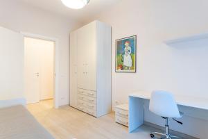 a bedroom with a desk and a blue chair at Casa L - Mimbelli Park Modern Quiet Apartment in Livorno