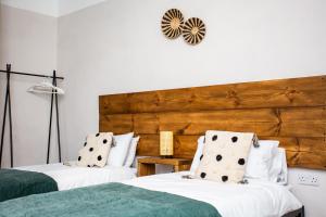 a bedroom with two beds and a wooden headboard at Pine Street Home by #ShortStaysAway in Willington Quay