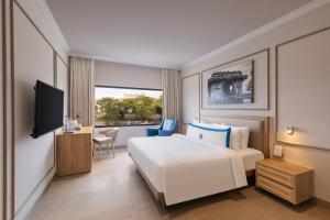 um quarto de hotel com uma cama e uma televisão em Fortune Valley View, Manipal - Member ITC's Hotel Group em Manipala