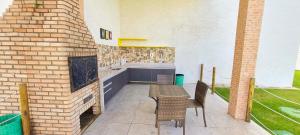 d'une terrasse avec une table, des chaises et un mur en briques. dans l'établissement Muro Alto Condomínio Clube, à Porto de Galinhas