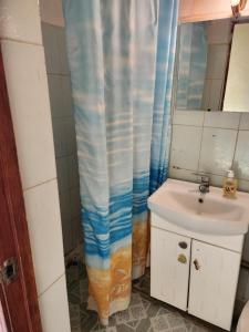 a bathroom with a sink and a shower curtain at Оазис in Almaty