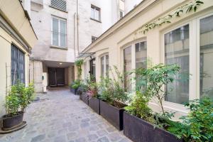 einen Innenhof mit Topfpflanzen an der Seite eines Gebäudes in der Unterkunft Superbe maisonnette neuve au coeur de Paris in Paris