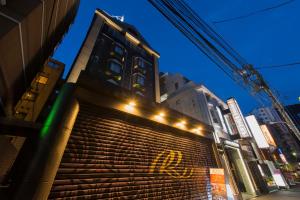 un edificio con una pared con graffiti amarillo. en HOTEL REFRAIN, en Tokio