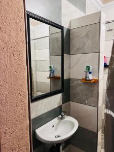 bagno con lavandino e specchio di The journey guest house a Mzinti