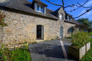 a stone house with a stone driveway at Ty-Voli - Magnifique Longère rénovée in Plougoumelen