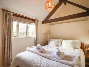 ColytonにあるThe Bull Penのタオルが敷かれた大きな白いベッドのある寝室