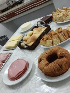 a table filled with different types of pastries and pies at Hotel Firenze in Londrina
