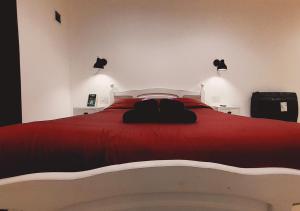 a bedroom with a red bed with two lights on it at Disfruta Mucho !!! in El Calafate +2 photos