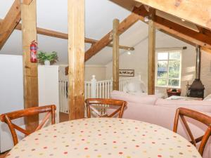 a dining room with a table and chairs in a room at The Old Barn in Colyton