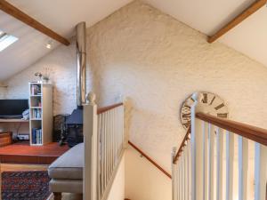 a staircase in a house with a clock on the wall at The Hay Loft in Colyton +22 photos