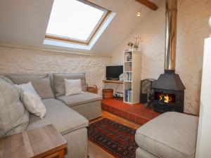 a living room with a couch and a wood stove at The Hay Loft in Colyton