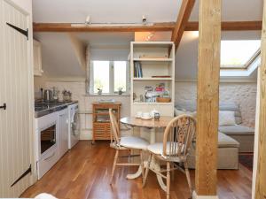 Colyton的住宿－The Hay Loft，厨房以及带桌椅的用餐室。