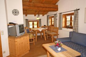 a living room with a couch and a tv at Bergbauernhof Simmerl in Sachrang