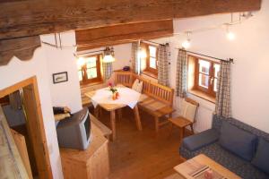 uma sala de jantar com uma mesa e uma televisão num quarto em Bergbauernhof Simmerl em Sachrang