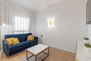 een woonkamer met een blauwe bank en een tafel bij Eurostars Gran Madrid in Alcobendas