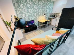 a room with a bed and a desk with a lamp at Hackney Studios by Sleepy in London
