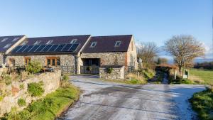 an old stone barn with solar panels on the roof at Stunning rural stay with idyllic views & great location in Talacre