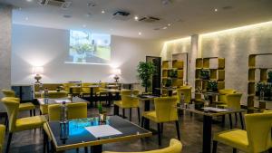 a restaurant with tables and yellow chairs in a room at Hotel Up Wellness & Spa in Foggia