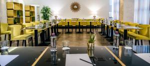 a dining room with tables and yellow chairs at Hotel Up Wellness & Spa in Foggia