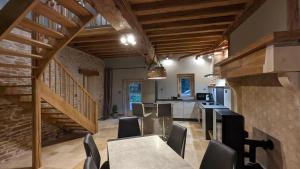 a kitchen and dining room with a table and chairs at La Ferme du Château in Beire-le-Châtel