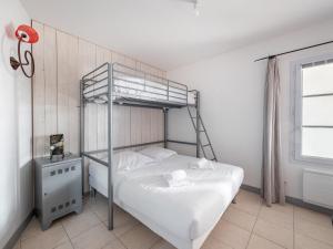 a bedroom with a bunk bed and a window at Charmante maison avec piscine partagee in Le Bois-Plage-en-Ré