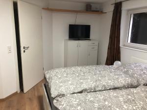 1 dormitorio con 1 cama y TV de pantalla plana en Ferienwohnung Emma, en Olsberg
