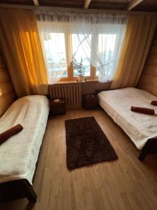 a bedroom with two beds and a window at Dom Wypoczynkowy Anetka in Białka Tatrzańska