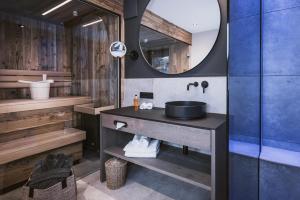 a bathroom with a sink and a mirror at Margarethenstein Boutique Hotel in Kaprun