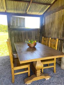 una mesa de madera con un bol de fruta. en Fazenda a 15 min do centro com Rio Particular en Bonito