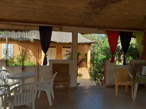 a patio with a table and chairs and a building at Campement Baobab in Poponguine