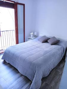 ein großes Bett in einem Schlafzimmer mit einem großen Fenster in der Unterkunft El Terrat de la Tecla - Dúplex Casc Antic in Tarragona