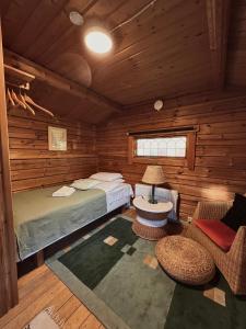 ein Schlafzimmer mit einem Bett und einem Stuhl in einer Hütte in der Unterkunft Råda Hotel in Hagfors