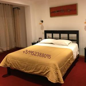 Un dormitorio con una cama con una señal de precio. en Hostal Le Prince, en Tacna