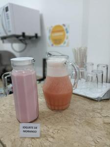 two mason jars filled with pink liquid on a counter at Hotel Firenze in Londrina