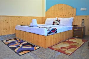 - une chambre avec un lit doté d'une tête de lit en bois dans l'établissement Spire View, à Manali