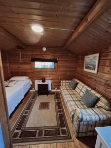 ein Zimmer mit einem Bett und einem Sofa in einer Hütte in der Unterkunft Råda Hotel in Hagfors