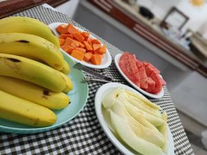 a table with bananas and fruit on plates on a table at Hotel Firenze in Londrina