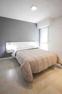 1 dormitorio con 1 cama grande en una habitación blanca en Departamento de un dormitorio - SAN LORENZO en Santa Fe