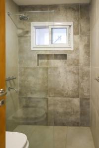 a bathroom with a glass shower with a window at Departamento de un dormitorio - SAN LORENZO in Santa Fe